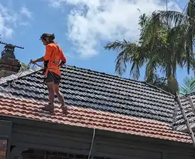 Expert team conducting roof painting and restoration services