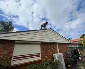 Aerial view of a residential roof being painted with high-quality coatings