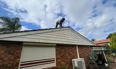 Skilled roof painters working on a home in South West Sydney, providing dependable roof maintenance services